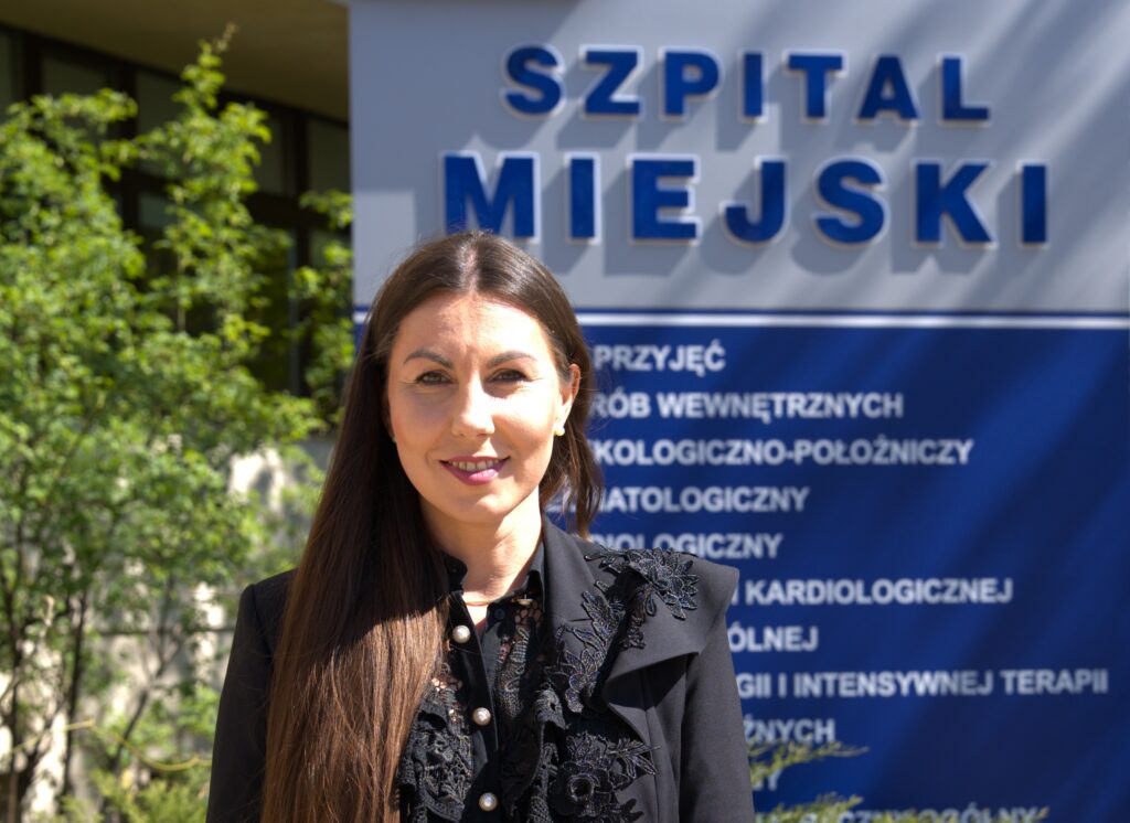 Kobieta na tle tablicy szpitalnej
